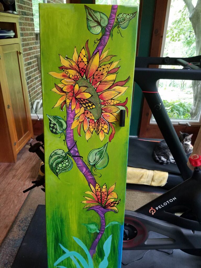 Vibrant folkedelic artwork featuring a stylized flower with layered, petal-like shapes filled with spirals, dots, and geometric patterns, set against a bold green background.